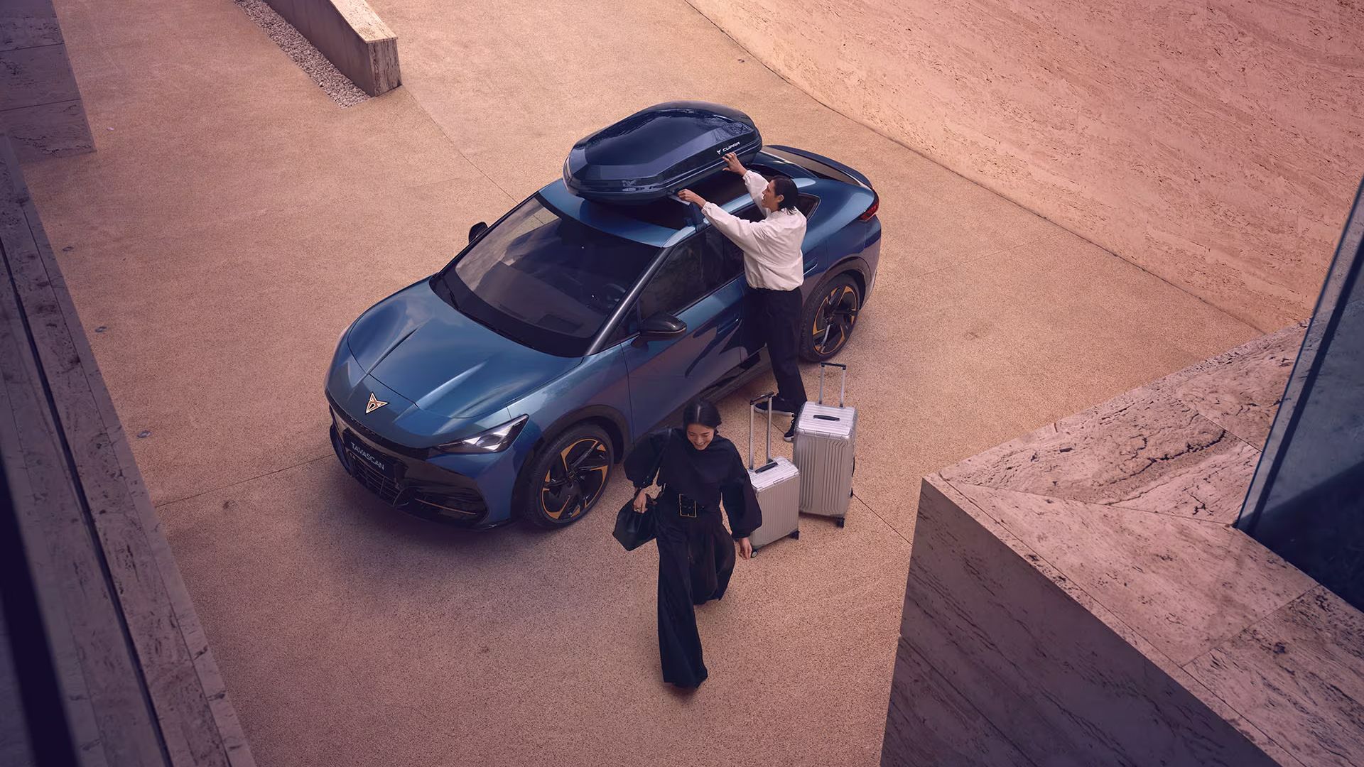 A couple  loading their luggage into a CUPRA Tavascan