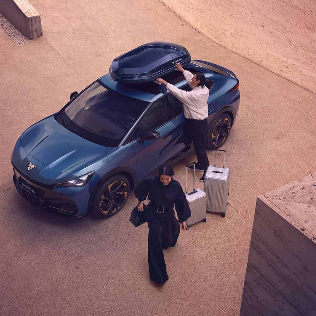 A couple  loading their luggage into a CUPRA Tavascan
