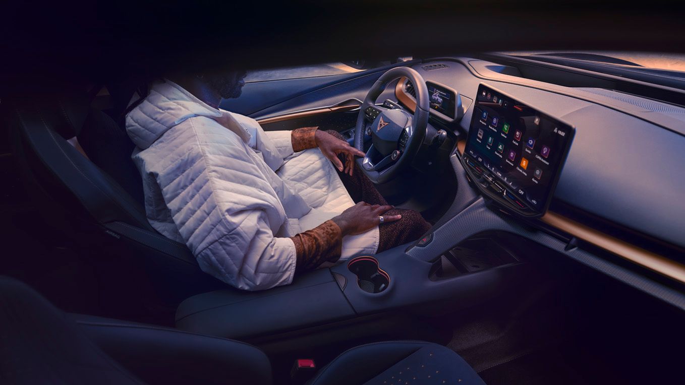 A guy sitting inside CUPRA Tavascan driver seat