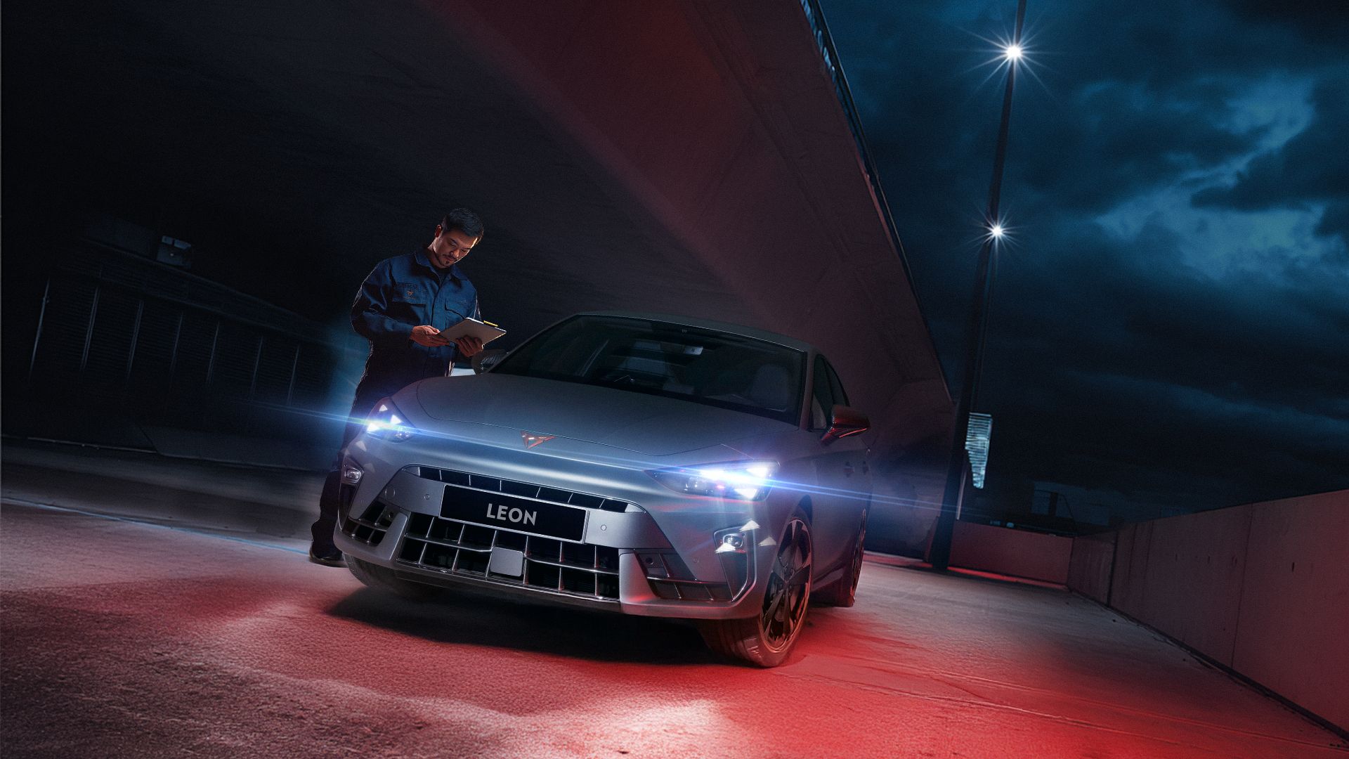 CUPRA Master inspecting a CUPRA Leon at night