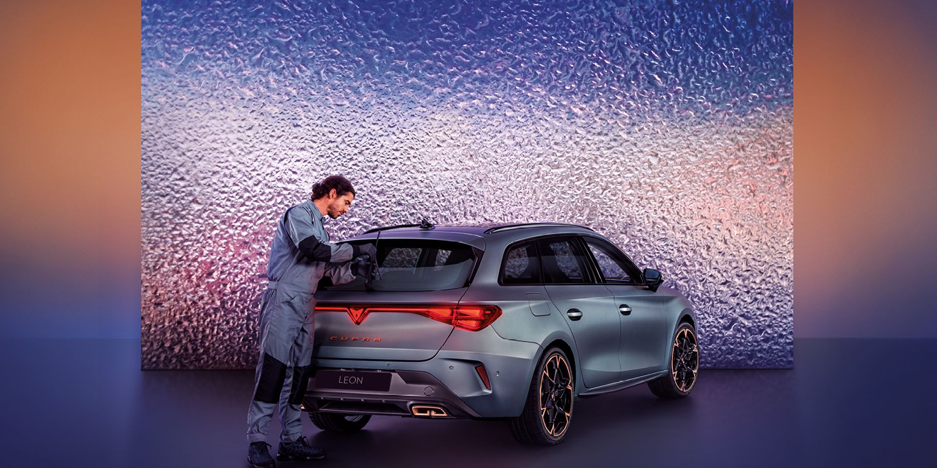 A CUPRA Servicing crew attending to the rear wiper of a CUPRA Leon