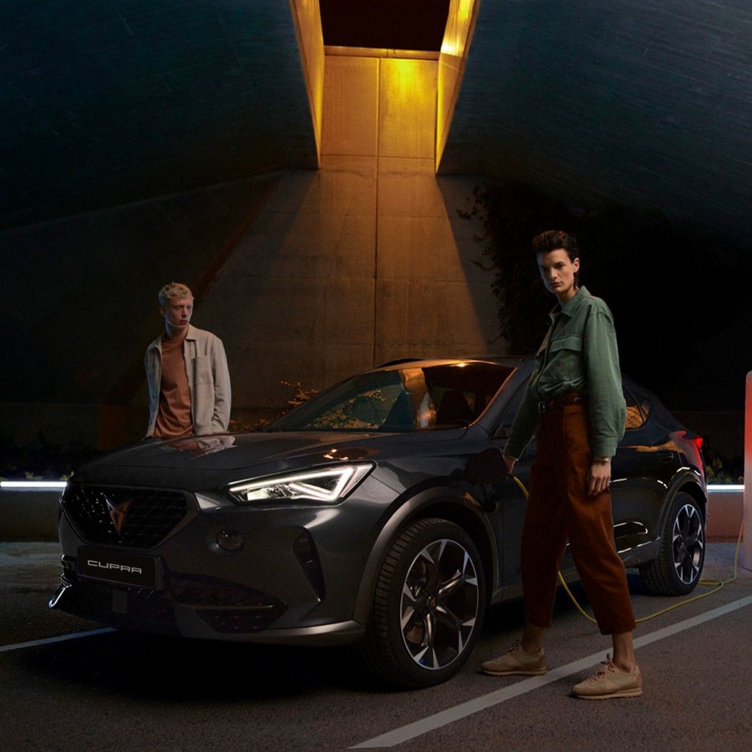 two guys charging CUPRA Leon