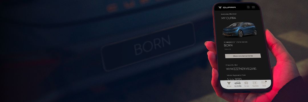 A person holding a phone looking at CUPRA SG app, behind there is a CUPRA Born
