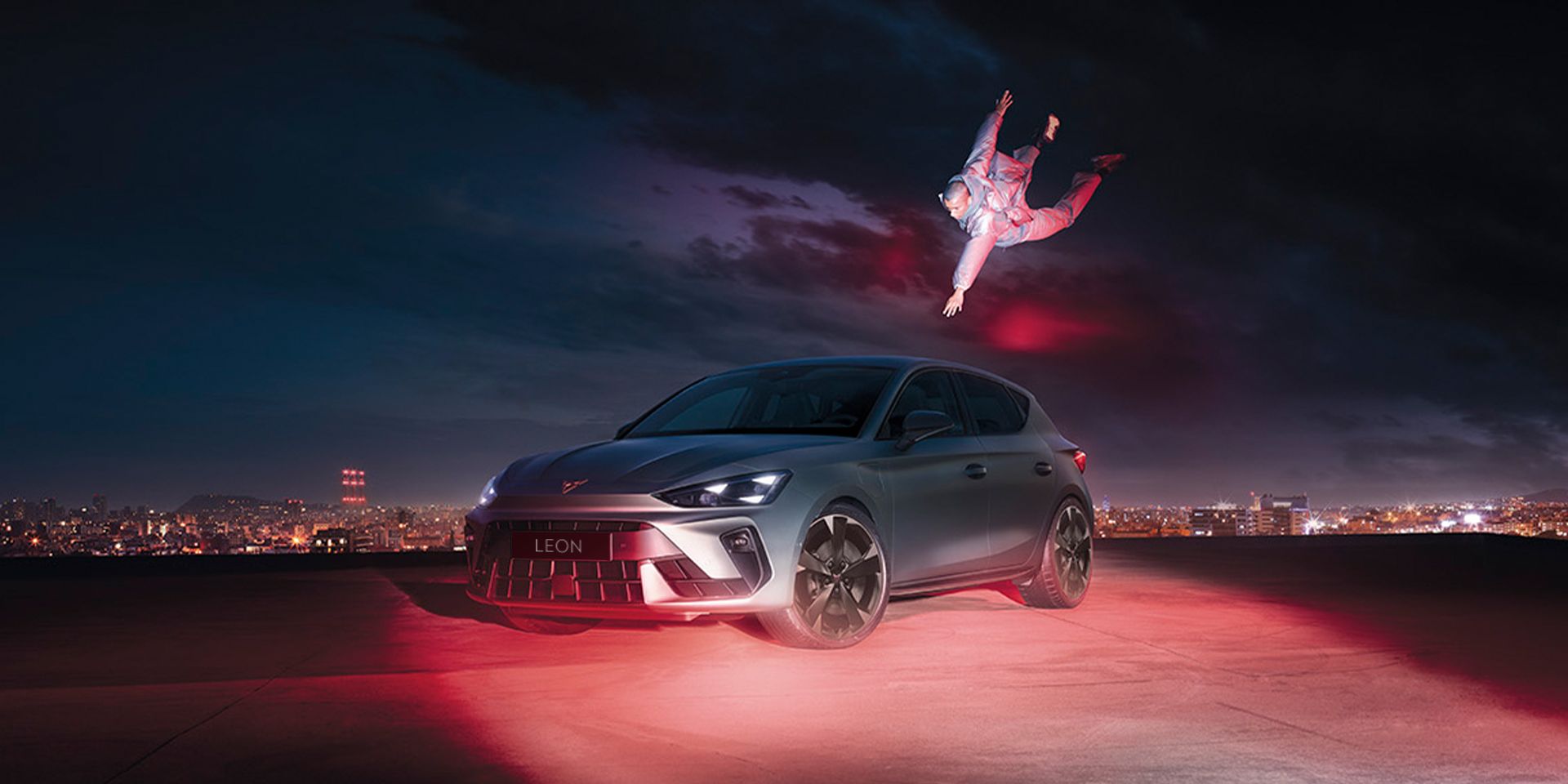 CUPRA Leon in Fjord Blue and with 18 inch GARBI alloy wheels parked with a man floating while reaching for the car