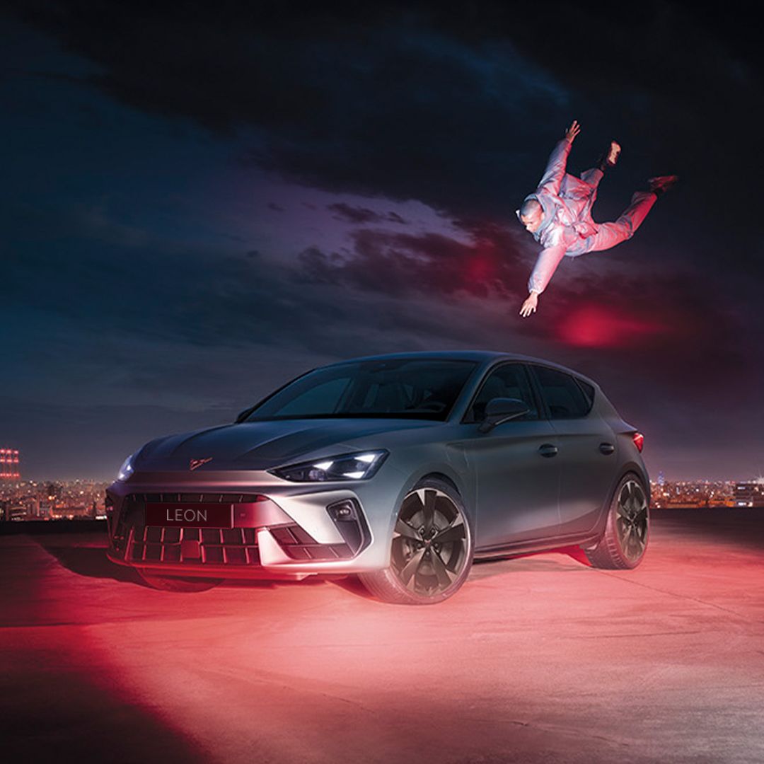 CUPRA Leon in Fjord Blue and with 18 inch GARBI alloy wheels parked with a man floating while reaching for the car