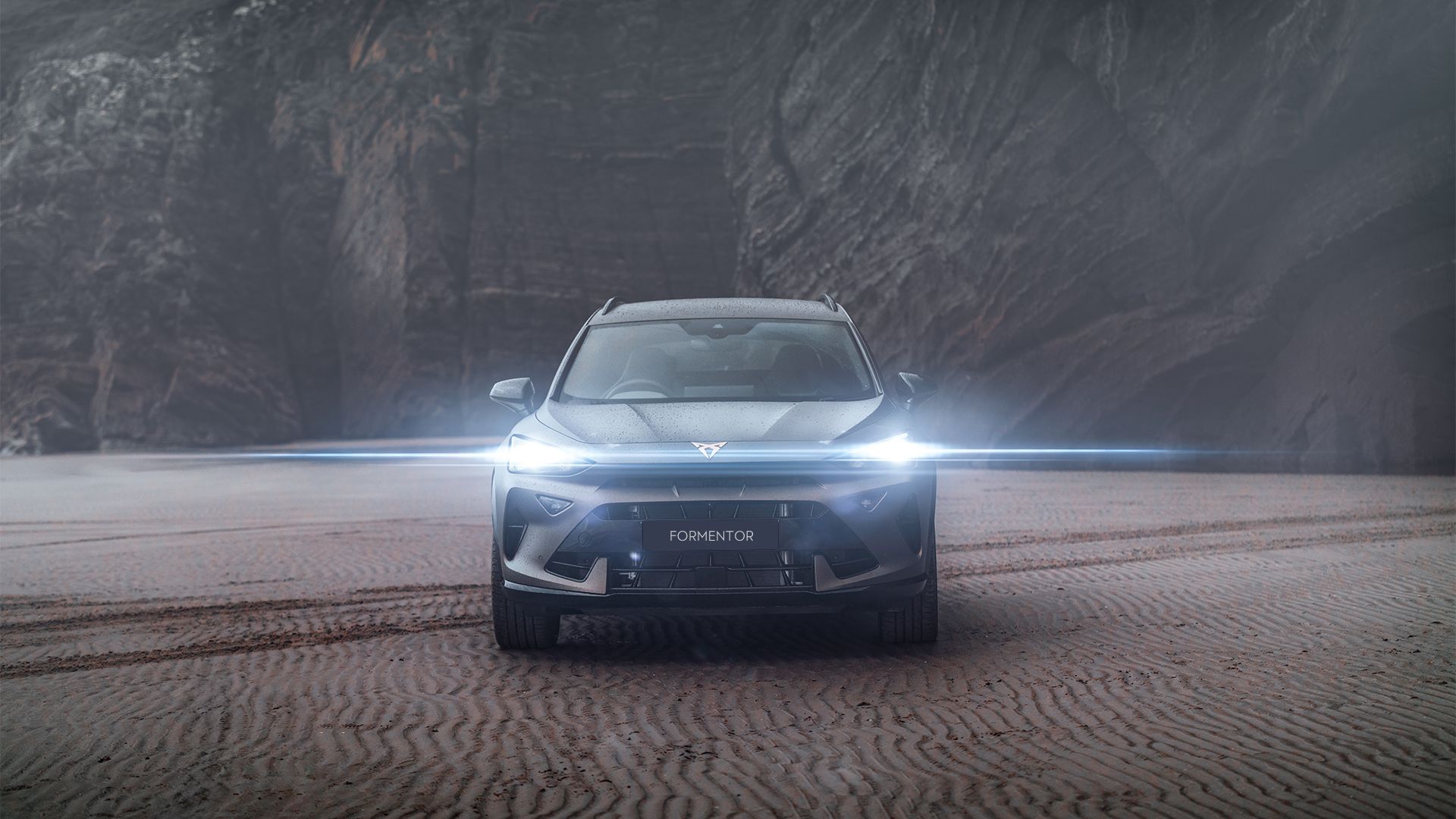 CUPRA Formentor parked in a deserted area with sand and mountain