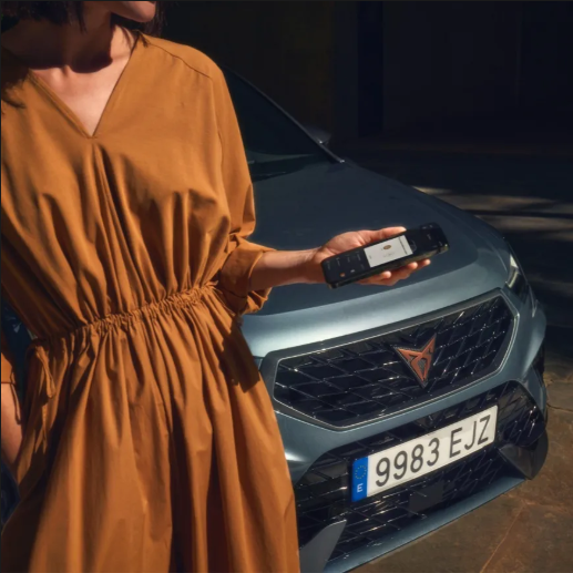 A lady holding her phone beside a CUPRA Formentor