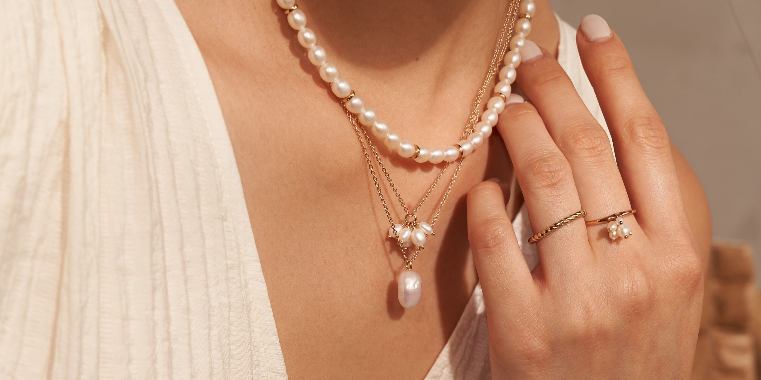 A lady's hands and neck with it's brand jewelries 