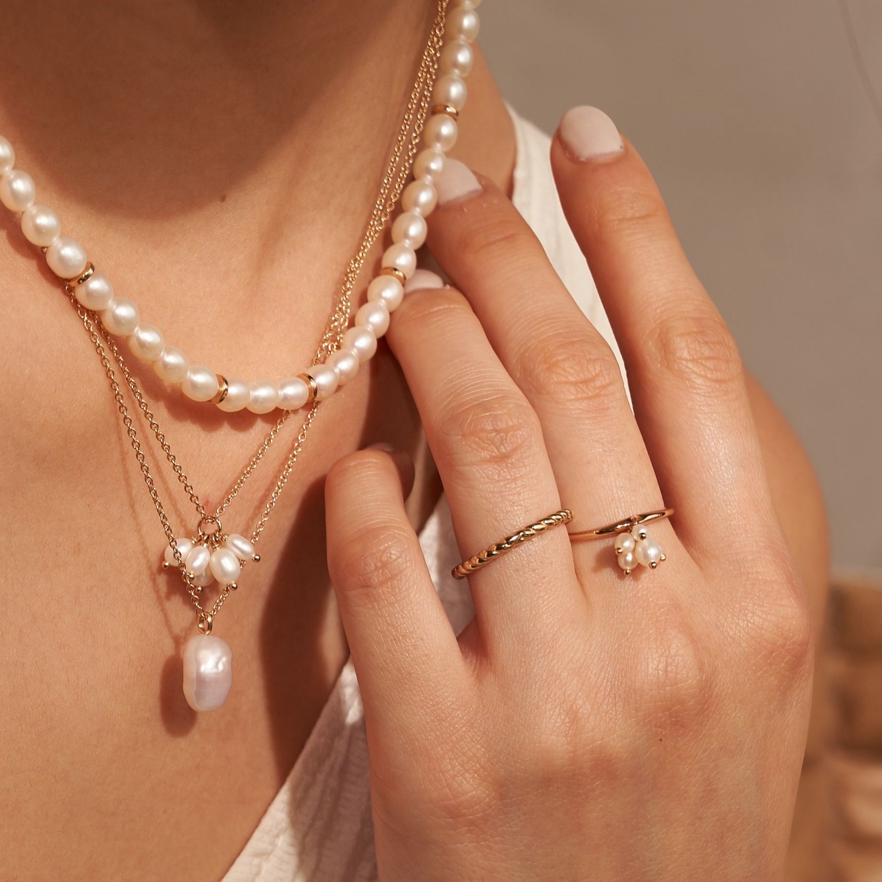 A lady's hands and neck with it's brand jewelries 