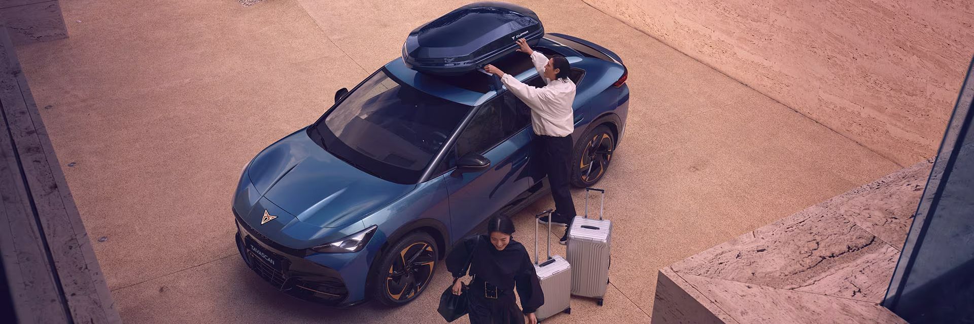 A couple  loading their luggage into a CUPRA Tavascan