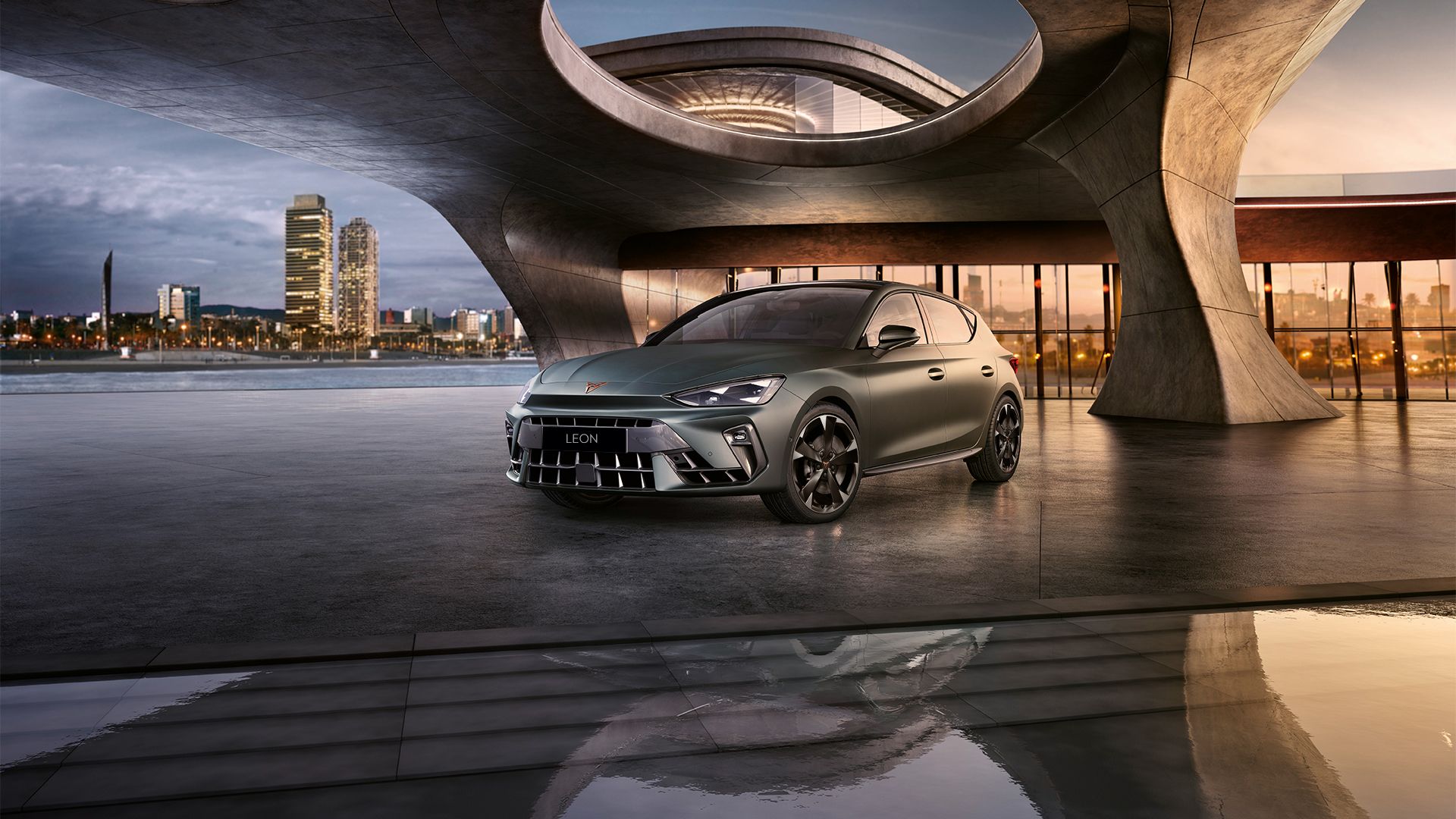 CUPRA Leon park by the side of a open air building facing a city view at the side 