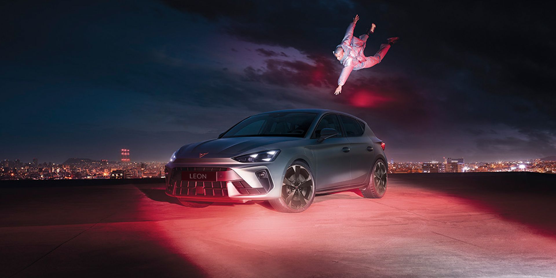 CUPRA Leon in Fjord Blue and with 18 inch GARBI alloy wheels parked with a man floating while reaching for the car