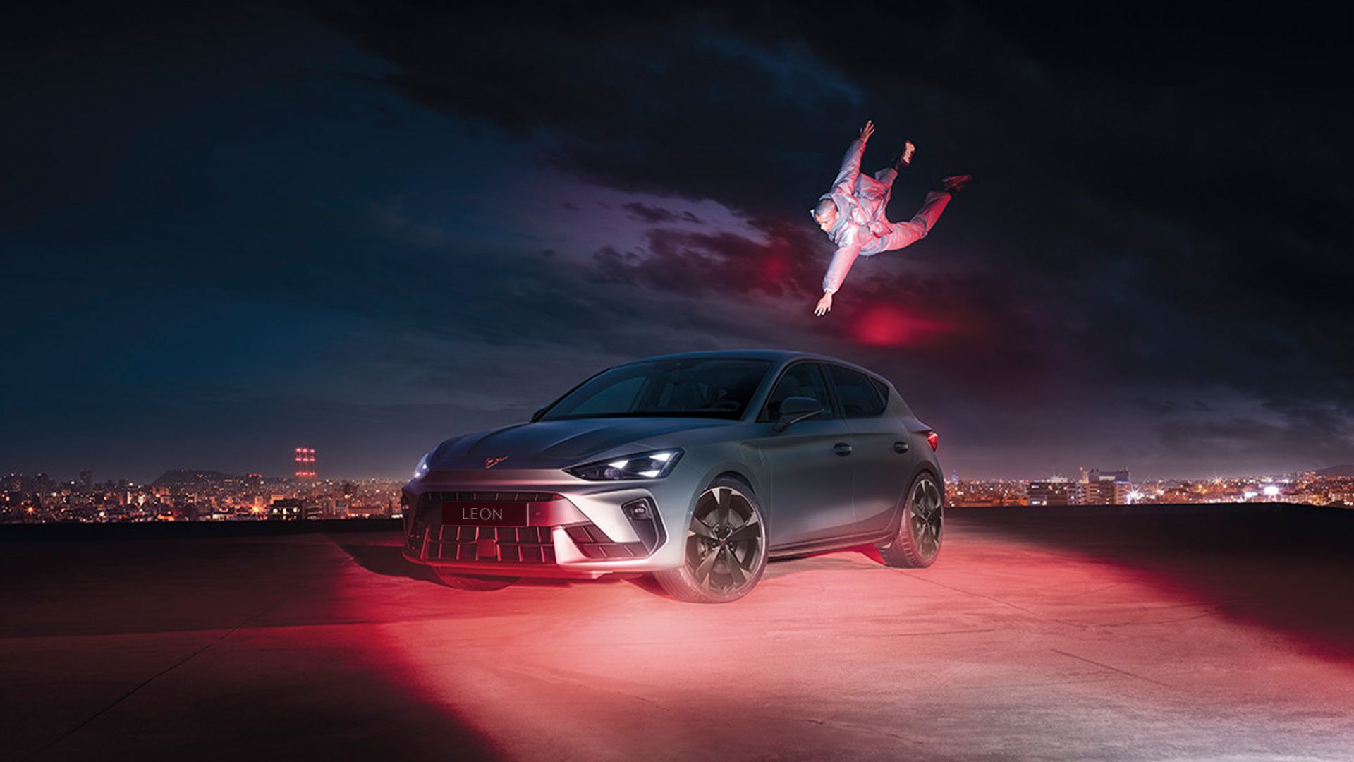 CUPRA Leon in Fjord Blue and with 18 inch GARBI alloy wheels parked with a man floating while reaching for the car